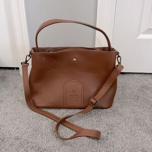 Camel/Brown leather crossbody with three compartments inside.